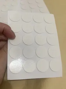 White circular double-sided adhesive dots for candle wicks, convenient sticky pads for crafts.