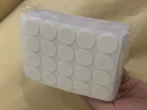 Detail view of double-sided adhesive glue dots in clear packaging, ideal for candle wick fixing.
