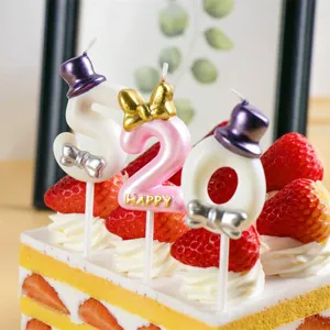 Close-up detail of creative 520 number birthday cake candles with cute hats and bow decoration.