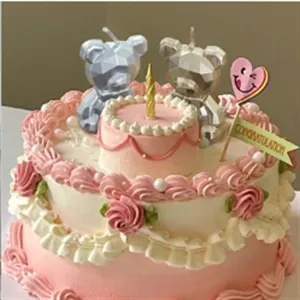 Geometric silver bear birthday candle detail view for children party celebration cake decor.