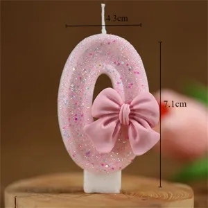 Pink glitter number zero birthday candle with cute bow, perfect for kids and adult party decor.