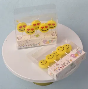 Yellow cute smiley face candles set for birthday cake, dessert decoration, children's party.