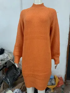 Close-up detail of the orange turtleneck knitted sweater dress, showing soft fabric texture.