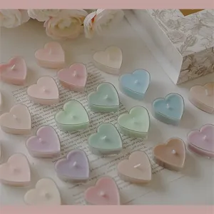 Bougies parfumées romantiques en forme de cœur pastel pour décoration de Saint Valentin et dîner.