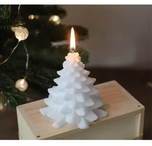 Primo piano dettagliato di una candela profumata ad albero di Natale bianca accesa.