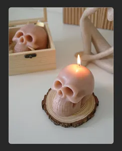 Λεπτομερής λήψη αρωματικού κεριού σε σχήμα ροζ κρανίου που καίει πάνω σε ξύλινο σουβέρ.