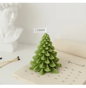 Candela profumata albero di Natale in primo piano, cera testurizzata decorazione festiva.