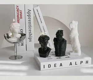 Vista dettagliata di candele profumate a forma di statue estetiche, busti di David e Venere.
