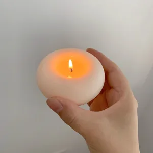 Détail de bougie parfumée en forme de donut artisanal, cire blanche décorative pour intérieur.