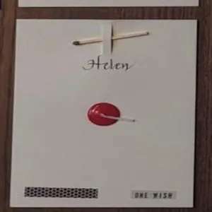 Detailed close-up view of creative greeting card featuring match and red wax seal, paper texture.