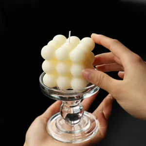 Gros plan sur la bougie parfumée esthétique en cubes sur support en verre, idéale pour la déco.