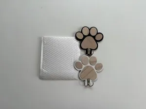 Wooden paw print wall hook detail view showcasing the dual metal hooks and packaging bag.
