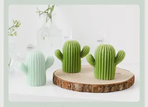 Detailed close-up of cute green cactus scented candles displayed on wood slice for home decor.