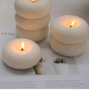 Vue détaillée de bougies parfumées créatives en anneau, décor blanc esthétique.