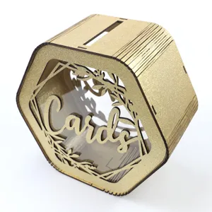 Close-up detail of hexagonal wooden wedding card box with gold glitter finish and hollow design.
