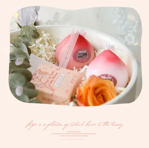Peach scented candle and cherry blossom soap gift box detail view with floral decor.