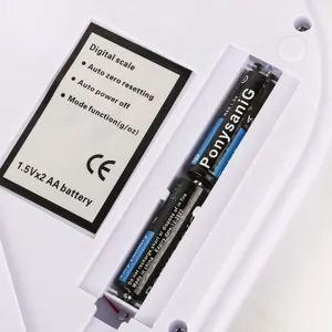 Vue du compartiment à piles de la balance de cuisine avec étiquettes de spécifications.