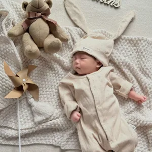 Infant baby ribbed romper with cute bunny ear hat, soft knit newborn sleeper in beige aesthetic.