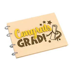 Close-up detail of wooden graduation photo album cover with engraved text and spiral binding.