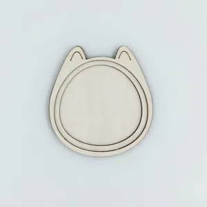 Gros plan détail du cadre de broderie en bois forme chat et aimant de réfrigérateur.