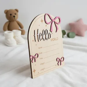 Dettaglio cartello annuncio nascita neonato in legno, segno hello world con fiocco rosa.