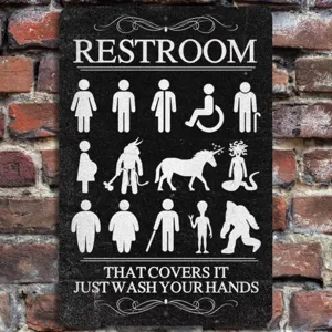 Closeup detail of funny novelty restroom hanging sign on brick wall, creative decor plaque.