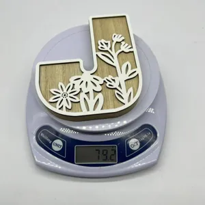 Wooden letter J decorative ornament featuring white floral carving design for desktop decor.