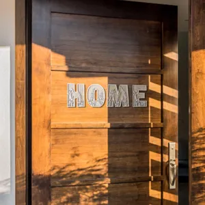 Wooden HOME sign with floral hollow-out design, rustic door hanging home decor piece.