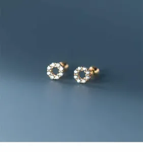 Close-up detail shot of exquisite minimalist round halo paved diamond stud earrings for women.
