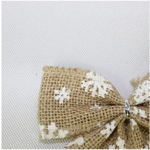 Nahaufnahme Detail der rustikalen Jute Weihnachtsschleife mit weißem Schneeflockenprint.