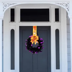 Detailed view of Halloween black purple tinsel wreath with orange truck ribbon bow.