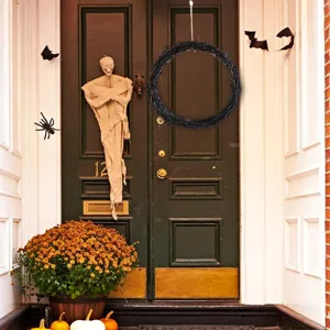 Nahaufnahme des schwarzen Zweigkranzes, der an einer Halloween Türdekoration hängt.