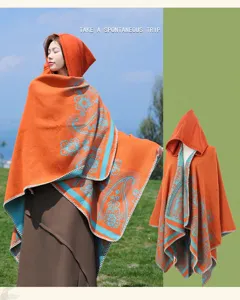 Detail shot of the ethnic hooded cloak featuring vibrant paisley patterns and warm thick fabric.