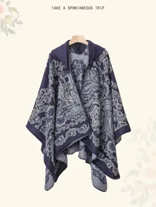 Detailed view of the elegant blue hooded knitted cape featuring intricate paisley pattern.