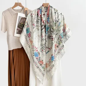 Vista dettagliata del lusinghiero foulard di seta con intricati motivi floreali e di uccelli.