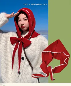Detailed view of the red knitted balaclava with a cute bow and cozy white trim for autumn.