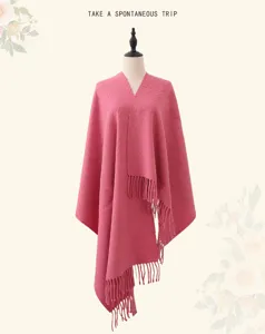 Pink wool shawl detail showing soft texture, cozy drape and elegant fringe trim for autumn.