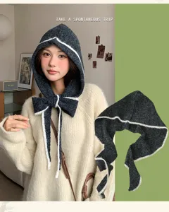 Knitted hooded balaclava scarf with white trim and bow detail, cozy winter accessory detail.