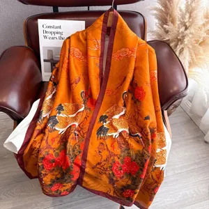 Close-up detail of the vintage orange silk scarf with traditional crane and flower print.