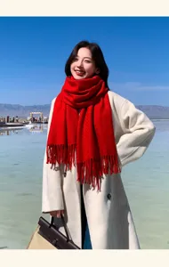 Detailed closeup view of the cozy red winter wool fringe scarf worn in scenic view.