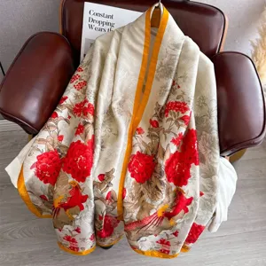 Detailed shot of a luxury vintage long silk scarf with elegant red floral and bird print.