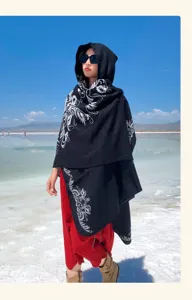 Cape à capuche style ethnique vue détaillée, châle noir avec broderie blanche pour voyage d'hiver.