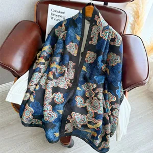 Detailed view of vintage black silk scarf featuring blue and gold traditional cloud patterns.