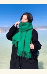Green wool winter scarf outdoor detail shot with fringe and elegant tassel design