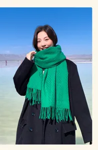 Cozy green wool scarf detail, soft texture and elegant tassels for autumn and winter outfits.