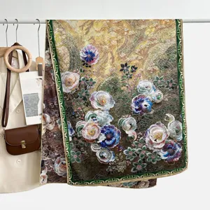 Detail shot of a vintage floral silk scarf with exquisite rolled hems and rich golden tones.