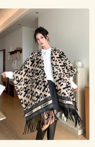 Detailed view of women's knitted fringed shawl, elegant patterned cape for autumn and winter.