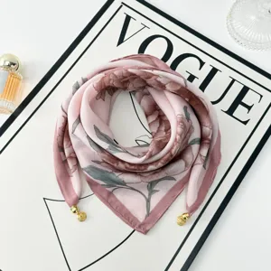 Detail view of pink floral square scarf with gold magnetic pendant clips for elegant women style.