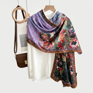 Detailed view of vintage printed silk scarf draped on white shirt with retro floral pattern.