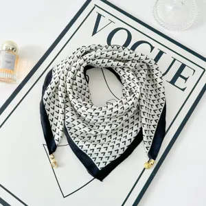 Stylish black and white geometric square scarf detail featuring chic gold corner metal charms.